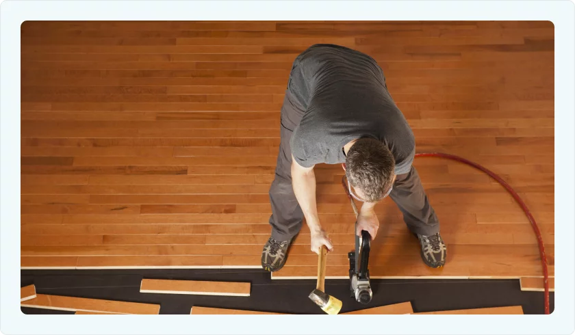 Man installing oak flooring for office in McAllen