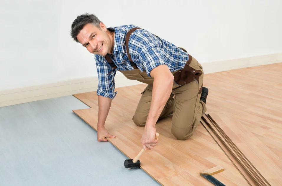 Man installing maple flooring for apartment in McAllen